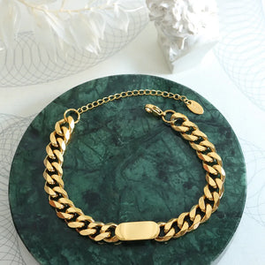 Gold chunky curb chain ID bracelet with oval plate and adjustable clasp.
