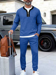 Men's royal blue track pants with a zippered top and black collar detail.