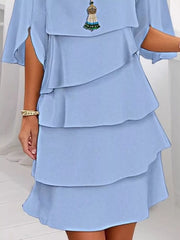 Light blue ruffled layered flutter sleeve dress with tiered skirt and tassel necklace.