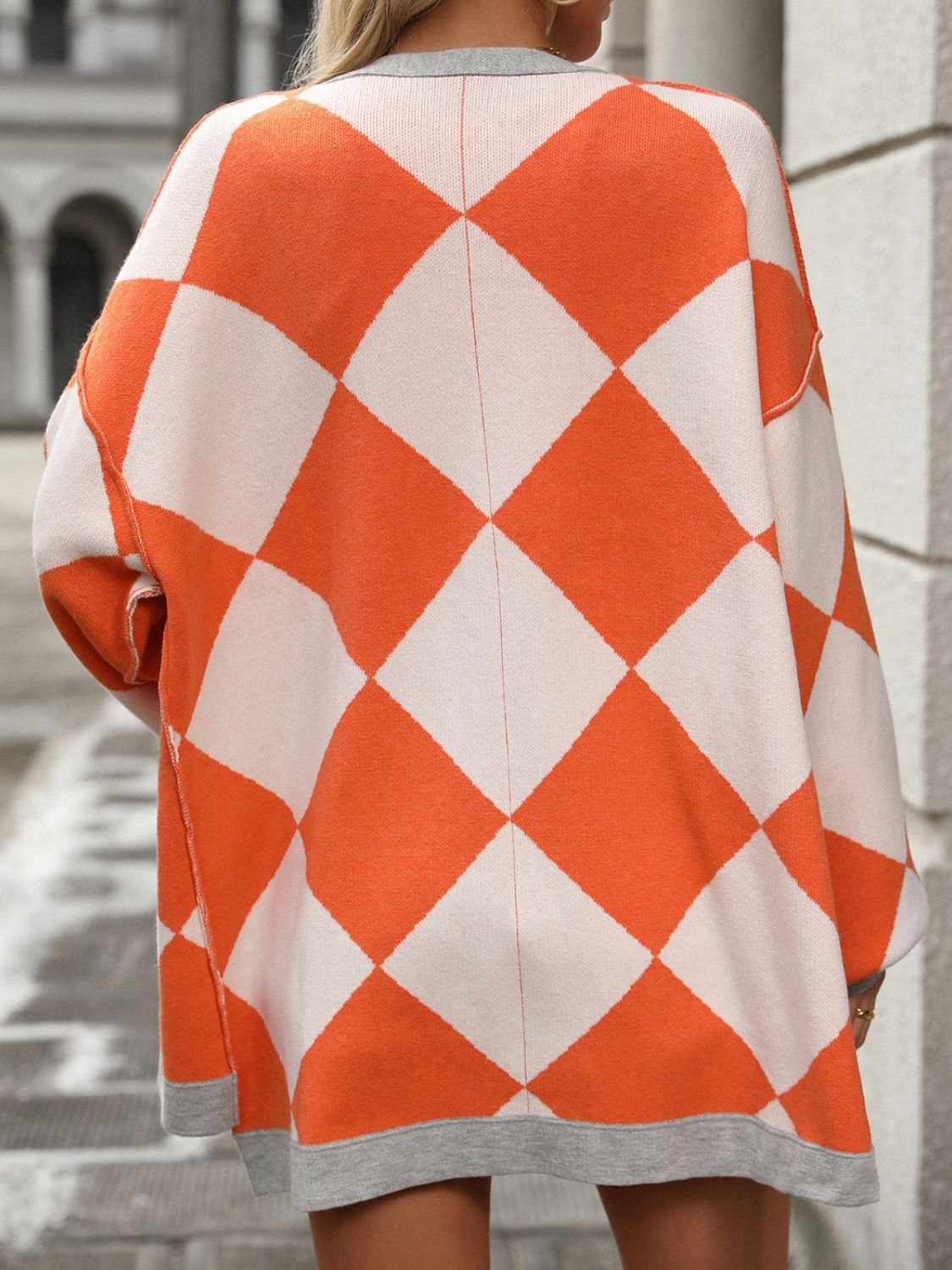 Orange and ivory argyle knit oversized cardigan with grey trim.