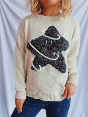 Beige knit jumper with embroidered starburst detail and white piping.