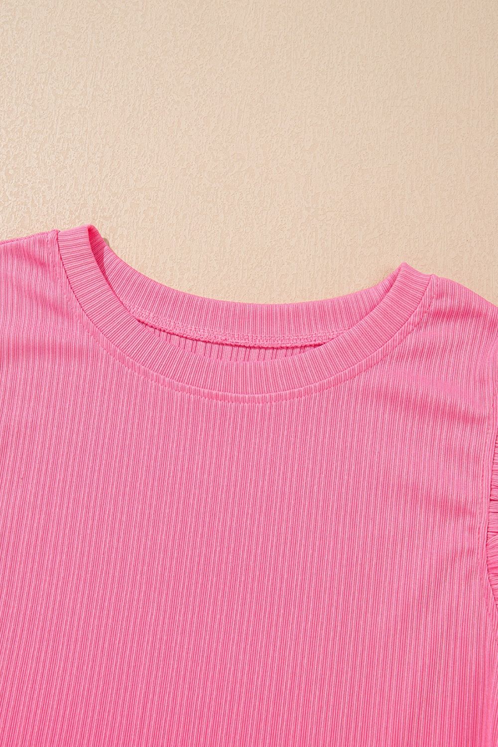 Pink ribbed knit top with ruffled sleeve detail