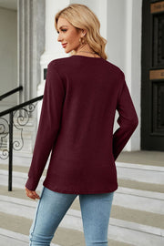 Burgundy waffle knit long sleeve top with a crew neck, styled with jeans.