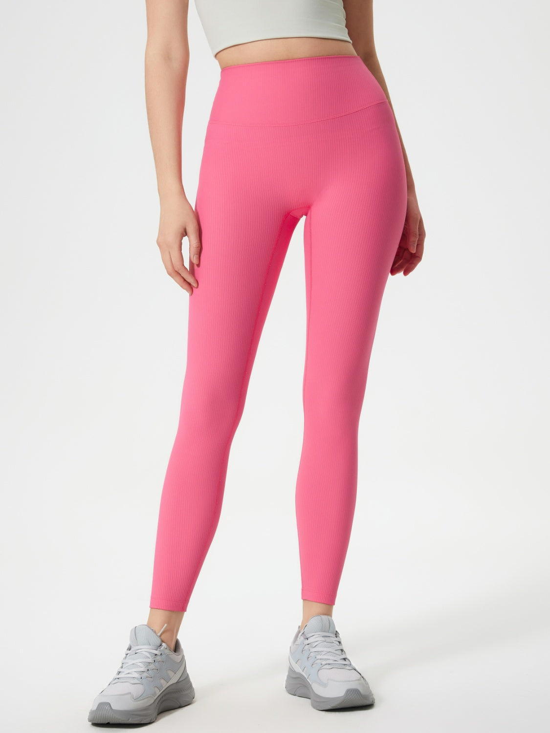 Pink ribbed high-waist leggings with a seamless fit, shown on a model.