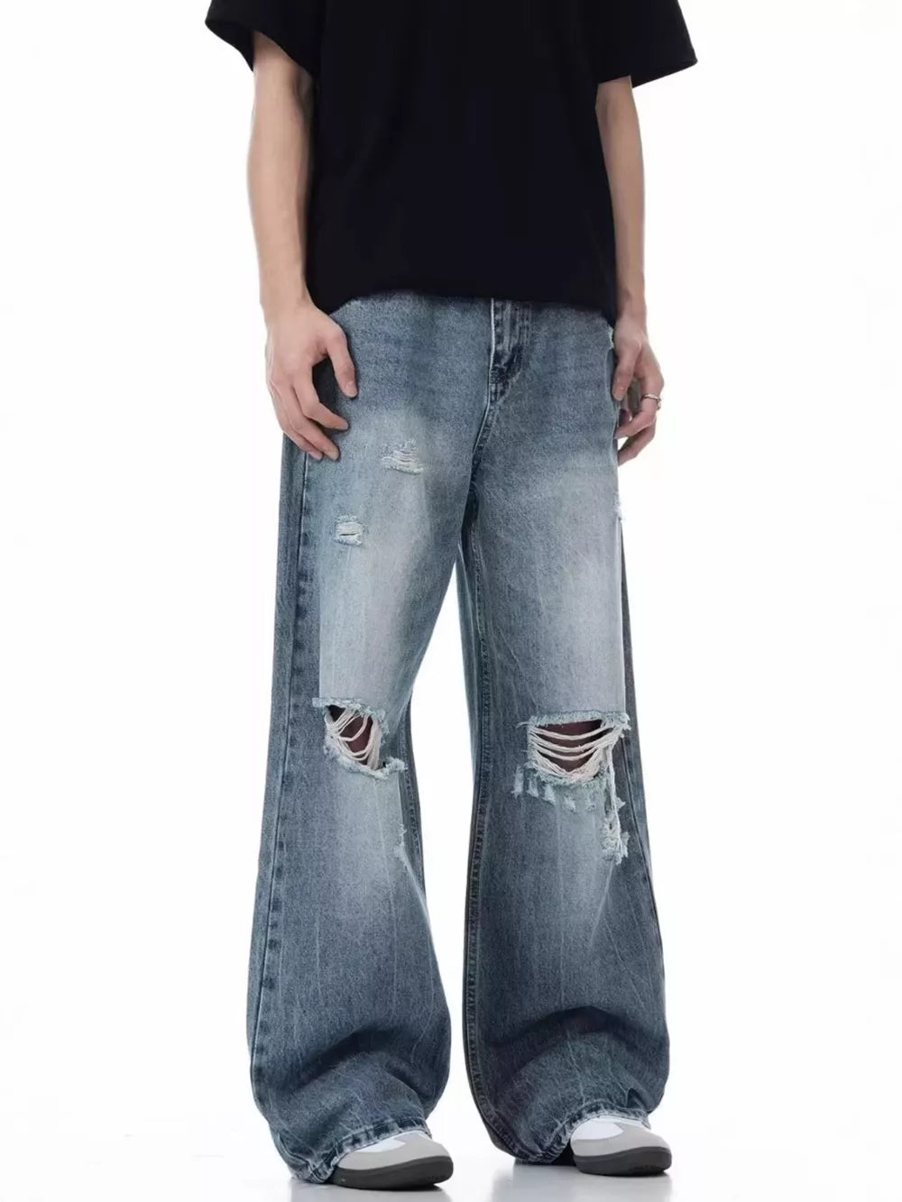 Men's blue distressed wide-leg cotton jeans with ripped details.