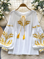 White embroidered tie-neck blouse with yellow wheat detail and tassels.