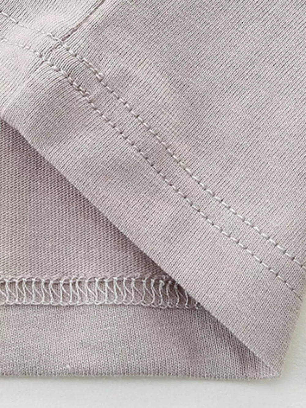 Gray cotton t-shirt detail showing stitching and fabric texture.