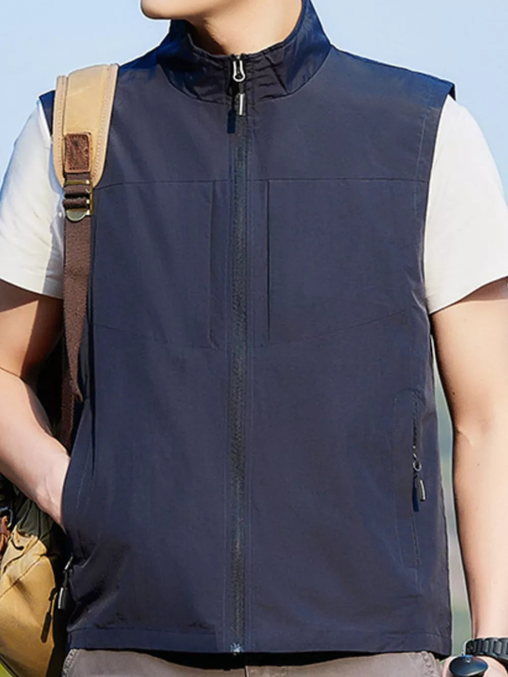 Dark blue zip up vest with stand collar, two chest pockets and side zip pockets.