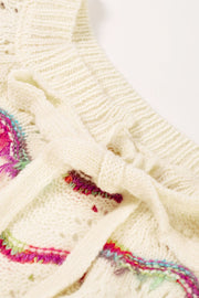 Cream acrylic knit sweater with colorful embroidered scallop detail and back tie.