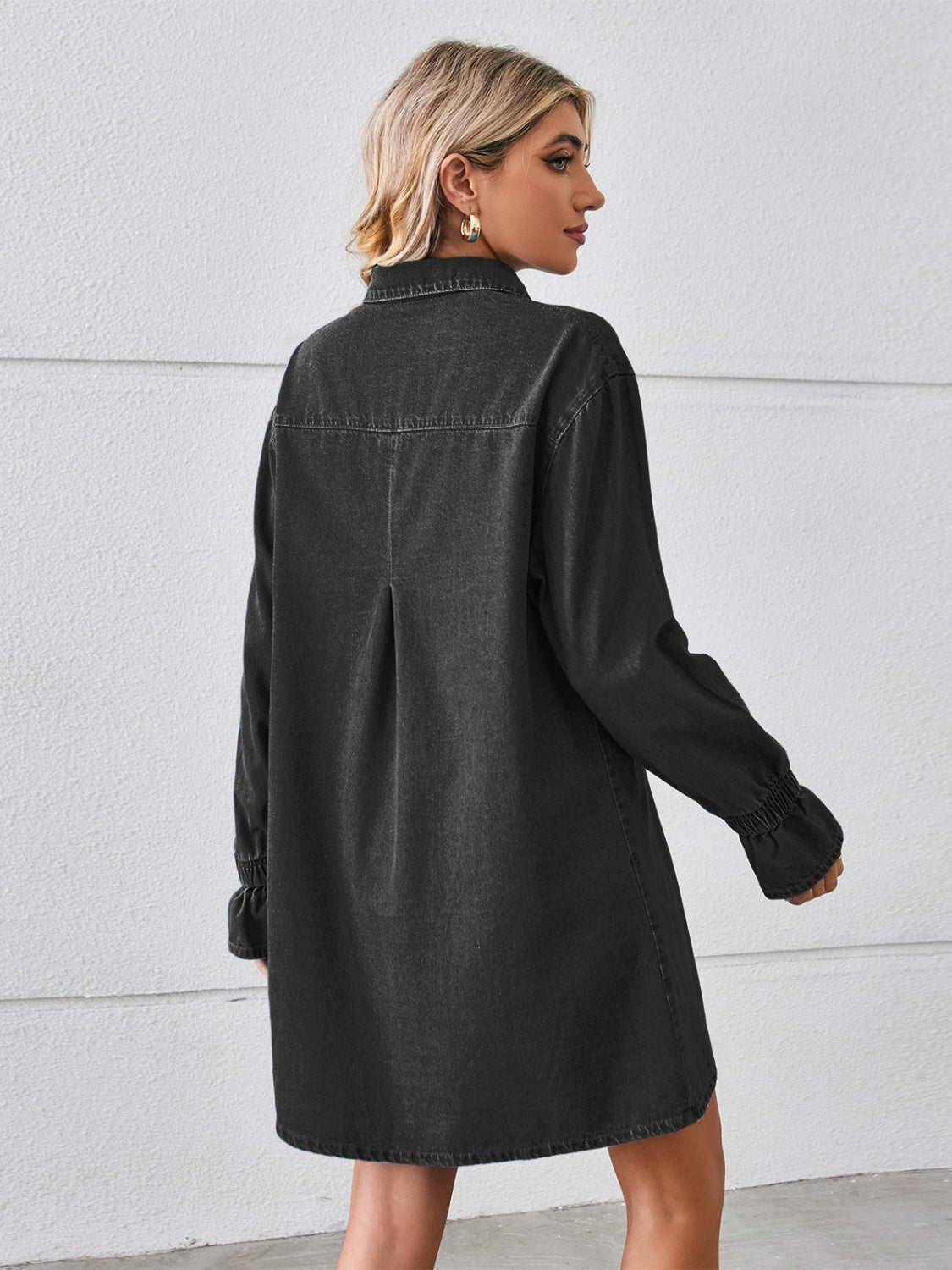 Black oversized denim shirt dress with button cuffs and a back pleat detail.