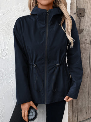 Navy utility jacket with cinched waist, hood, and zipper.