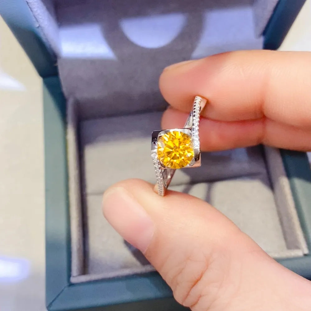 Silver twist ring with a bright yellow 1-carat moissanite center stone and diamond accents.