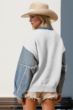 Denim Sleeve Starburst Knit sweater in light gray with distressed denim sleeves and frayed cuffs.