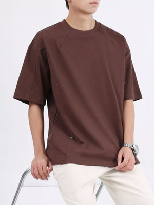 Dark brown cotton crew neck oversized t-shirt with raglan sleeves and subtle stitching details.