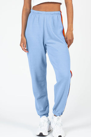 Light blue track pants with rainbow stripe detail on the side