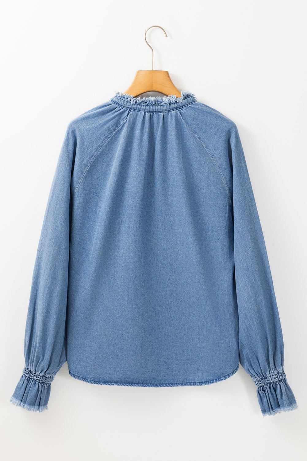 Light blue denim blouse with ruffled collar and cuffs, long sleeves.