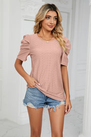 Pink perforated sleeve volume top with crew neck and puff sleeves.