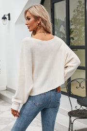 White off-shoulder ribbed knit sweater with balloon sleeves and boat neckline.