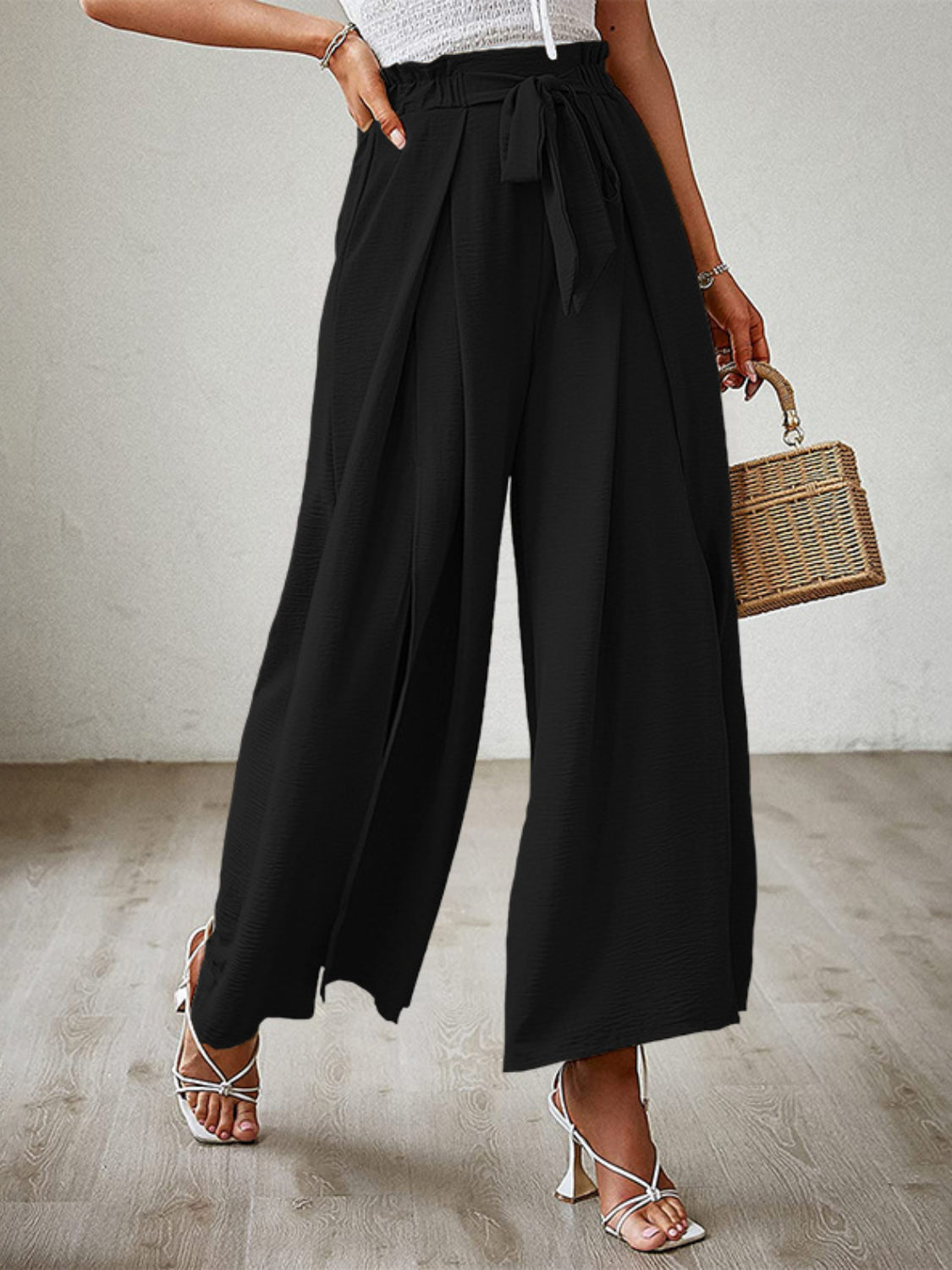 Black paperbag waist palazzo pants with side slits and a tie belt.