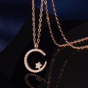 Rose gold necklace with crescent moon and star pendant, adorned with small crystals.
