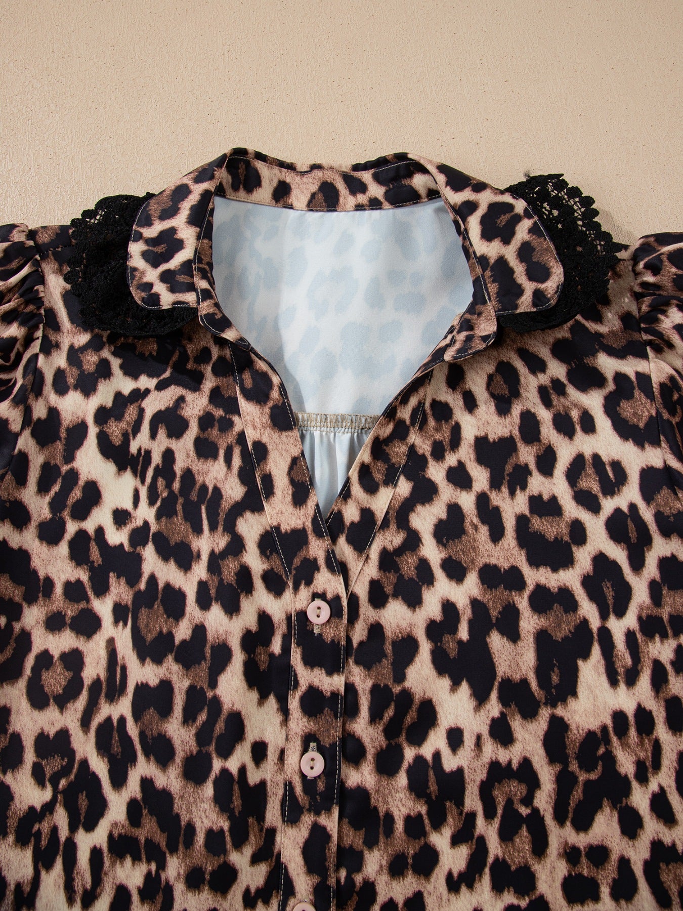 Women's leopard print button-up shirt with black lace collar detail.