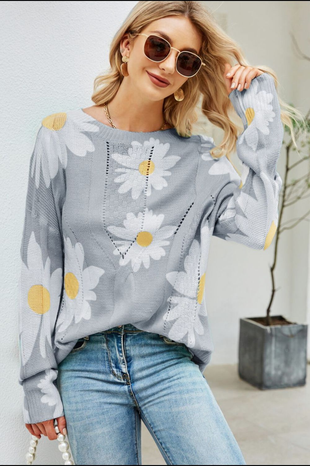 Light gray intarsia knit sweater with white daisies and yellow centers, featuring a V-neck detail.