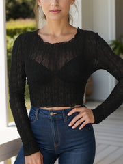 Black textured scallop-trim crop top with long sleeves and a sheer finish.