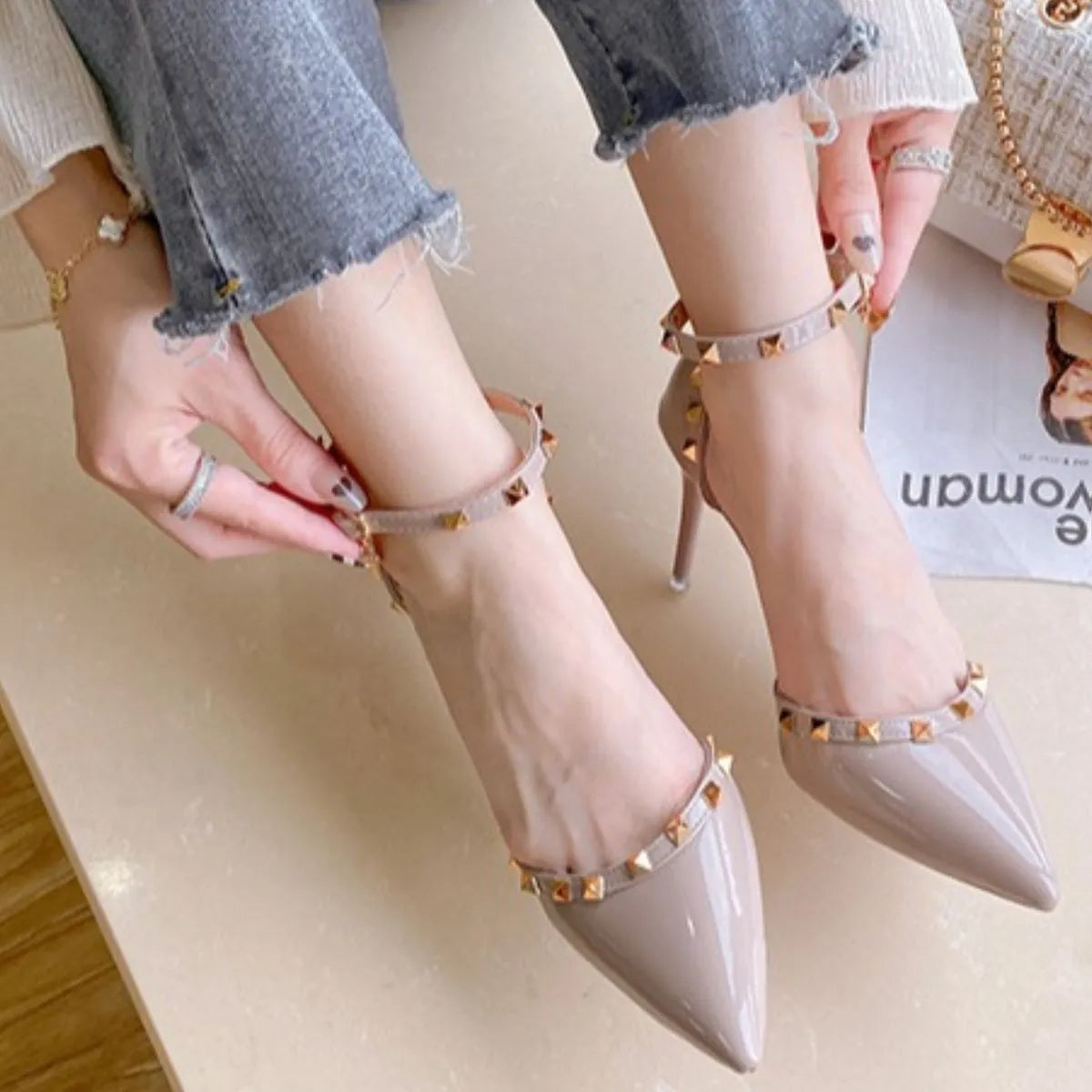 Apricot patent pumps with studded ankle straps and pointed toe.