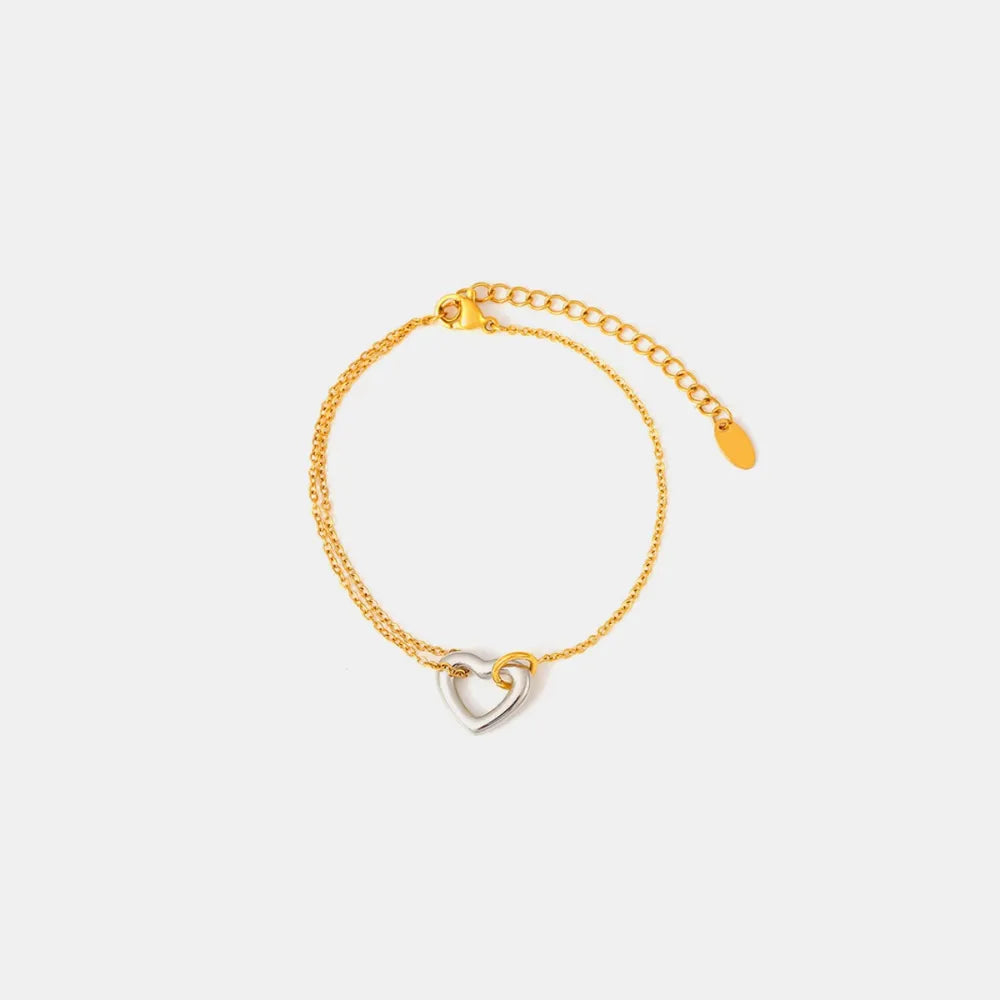 Two-tone heart charm bracelet with gold chain and adjustable clasp.