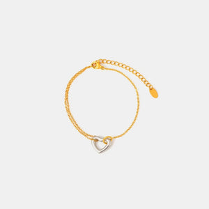 Two-tone heart charm bracelet with gold chain and adjustable clasp.