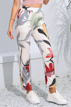 Botanical print slim-fit trousers in floral with a high waist and straight leg, styled with white sneakers.