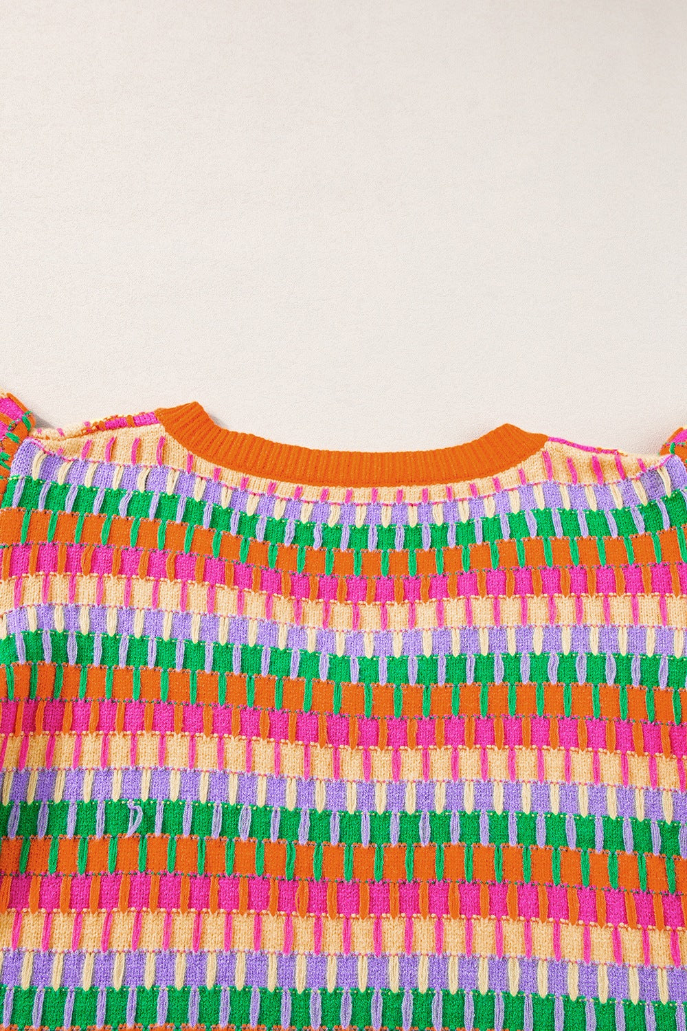 Geometric knit top with flutter sleeves in orange and green colorway.