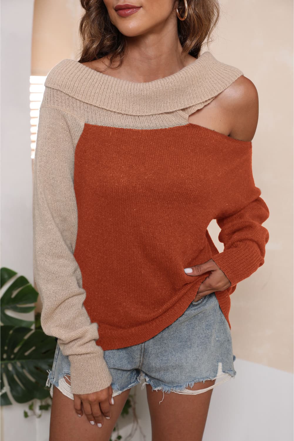 Asymmetric shoulder sweater in orange and beige acrylic with boat neck.