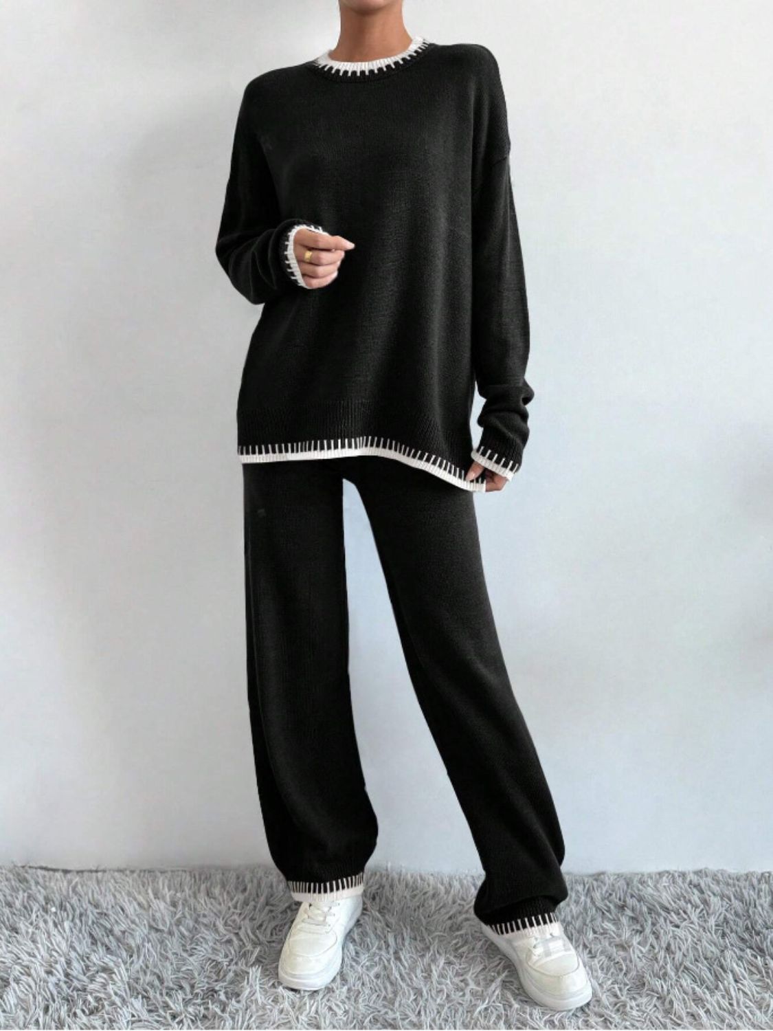 Black knit loungewear set with white trim detail on neckline, cuffs, and hem.