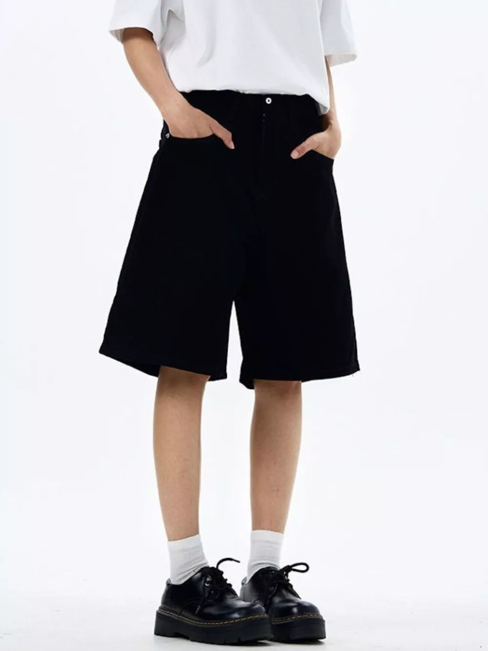 Black chino shorts with drawstring detail and pockets, styled with a white t-shirt and black shoes.