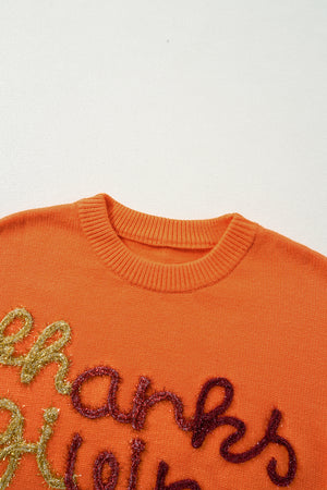 Orange knit sweater with sequin script detail and crew neck.