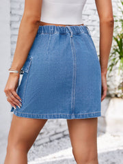 Denim mini skirt in blue with utility pockets, elastic waistband, and A-line cut.