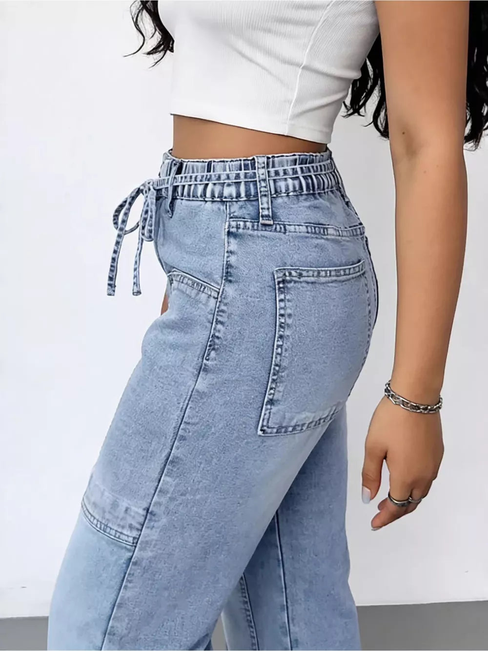 Light wash denim cargo jeans with drawstring waist and patch pockets.