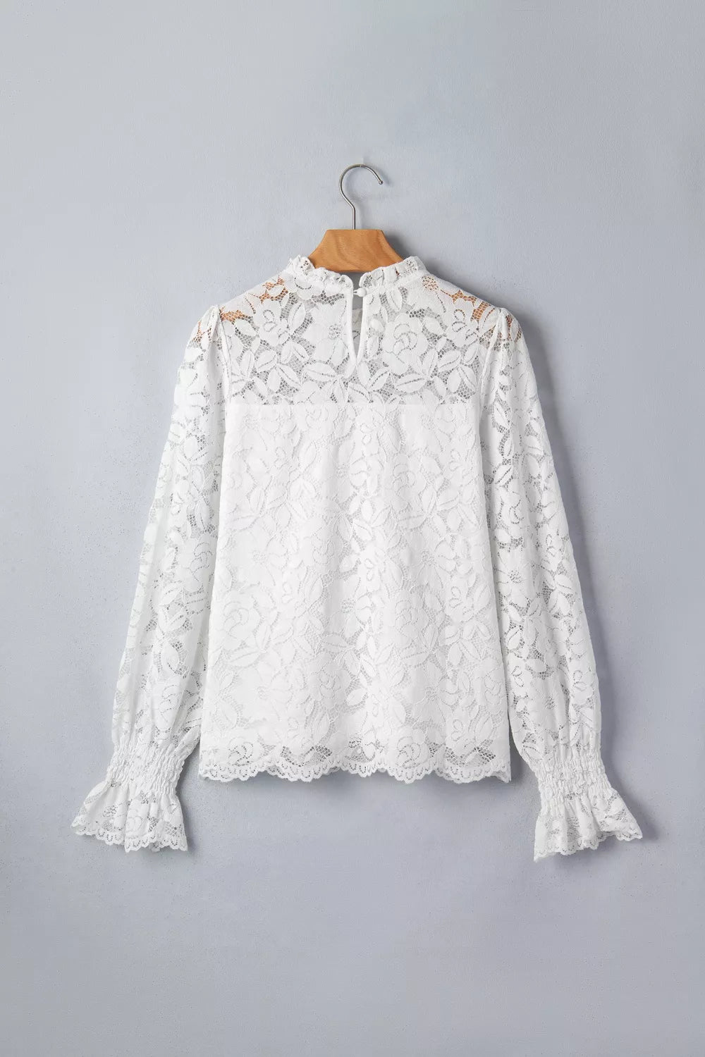 White lace blouse with ruffled neckline and cuffs, long sleeves