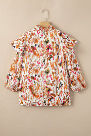 Blouse with abstract print, ruffled aura sleeves, and mock neck.
