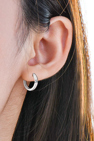 Silver pavé point huggie hoops with a single clear stone detail.