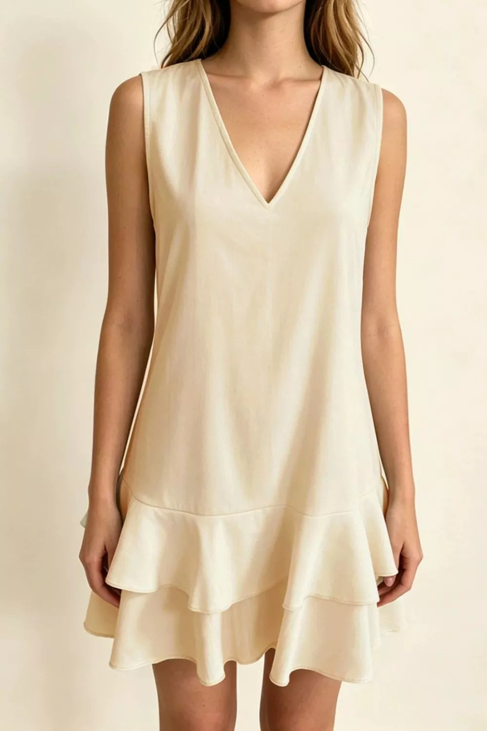 Beige v-neck mini dress with ruffle hem and sleeveless design