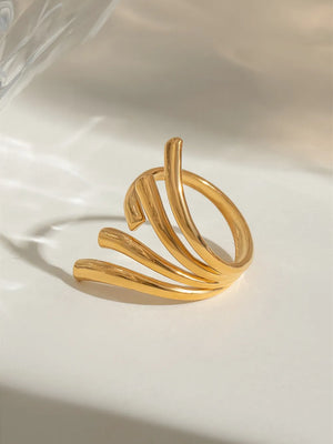 Gold sculptural spiral ring with multiple curved bands.