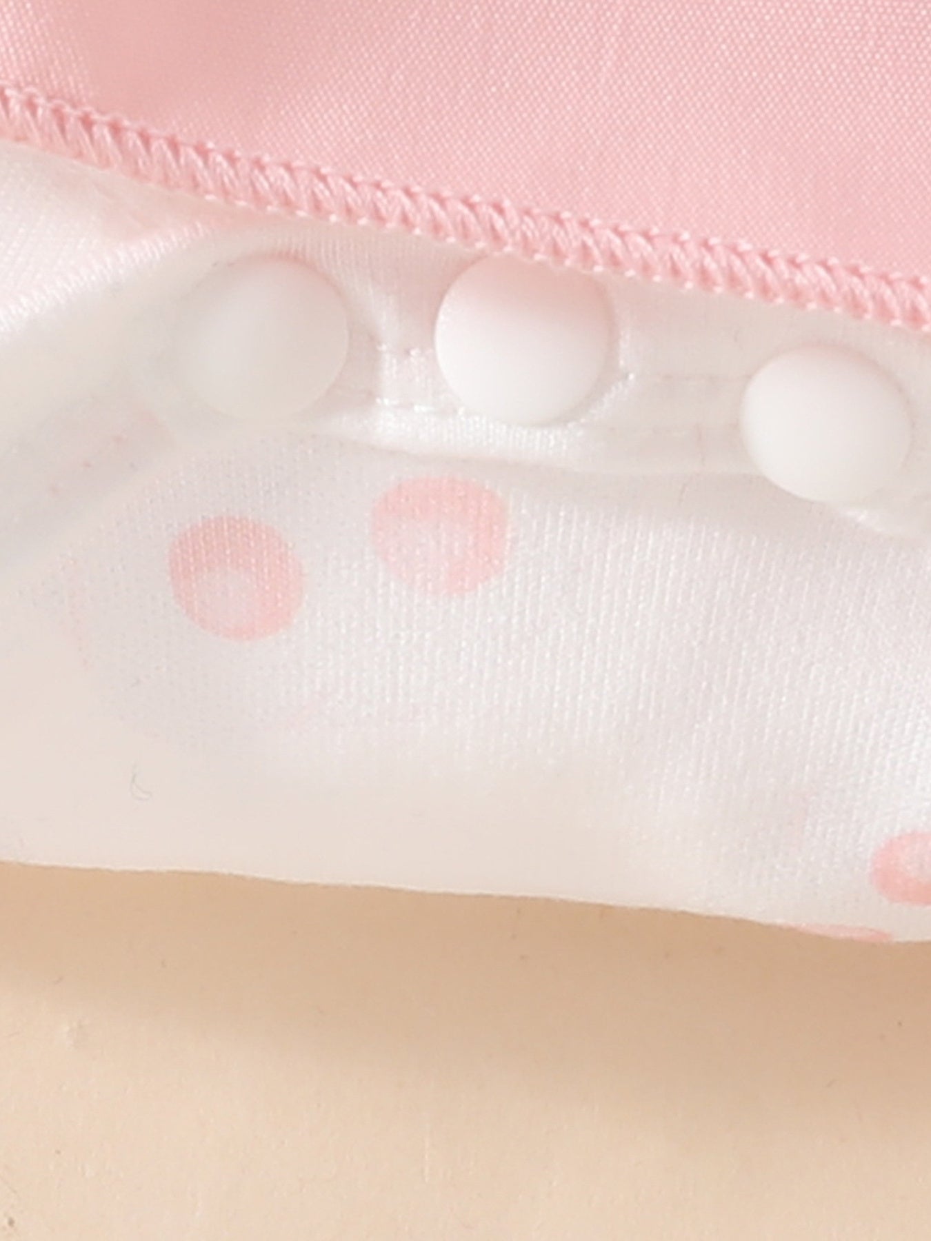Pink baby dress with white polka dots and snap closures