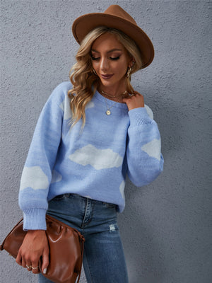 Light blue acrylic sweater with white cloud intarsia pattern, crew neck, and long sleeves.