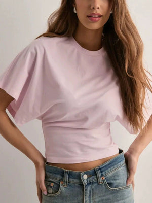 Blush pink batwing sleeve t-shirt with a fitted hem, styled with jeans.