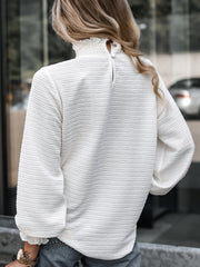 White textured blouse with smocked mock neck and puff sleeves.