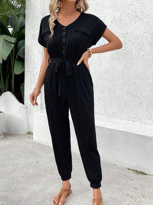 Black utility jumpsuit with short sleeves, V-neck, button front, tie waist, and pockets.