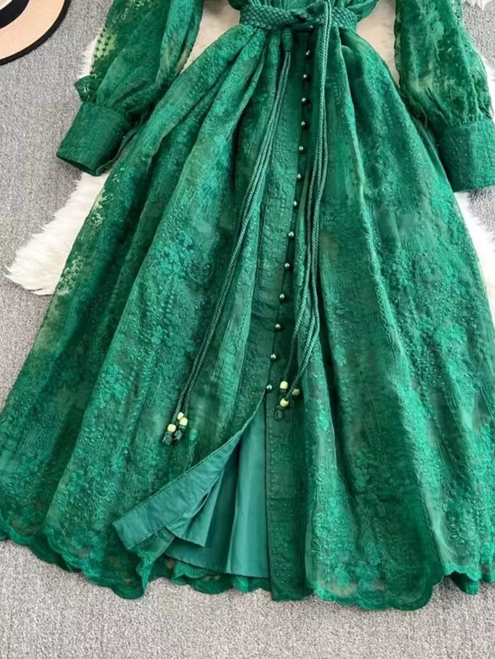 Green lace maxi dress with balloon sleeves, tie waist, and button-down front.