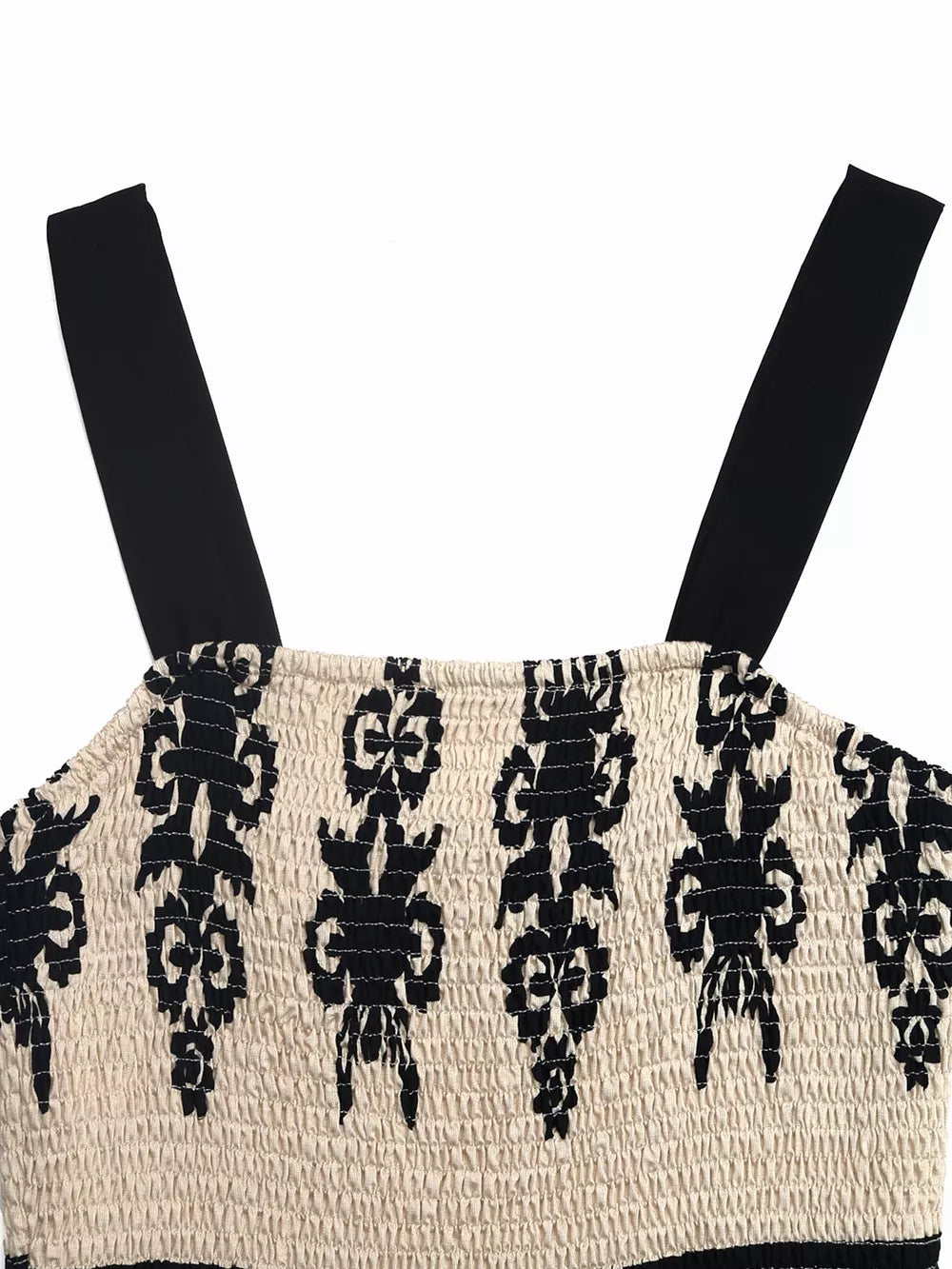 Bohemian smocked maxi dress with black straps and a black tribal pattern on cream fabric.